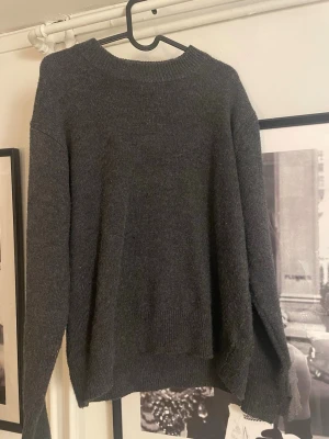 Mörkgrå stickad tröja  - Mysig mörkgrå stickad tröja med rund halsringning och långa ärmar från H&M