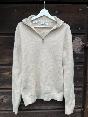 Selected homme Half-zip - Stickad beige tröja från selected homme med halv dragkedja framtill och hög krage. Tröjan har lång ärm och ribbade muddar vid ärmslut och nederkant. Perfekt för lager på lager och enkel att matcha med olika stilar. Stl S men oversized så passar mer Stl M/L