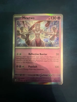 Pokémonkort Mewtwo 150/165 - Säljer ett holografiskt Mewtwo-kort från Pokémon med lila och silvriga detaljer. Kortet har 130 HP och attacker som Reflective Barrier och Psyslash. Perfekt för samlare eller Pokémon-fans som vill utöka sin kortsamling.