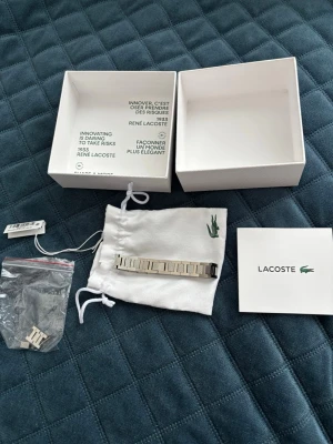 Lacoste armband i silver - Säljer en snygg original armband från Lacoste. Armbandet är aldrig använt då den inte passar mig. Priset kan diskuteras vid snabb affär.