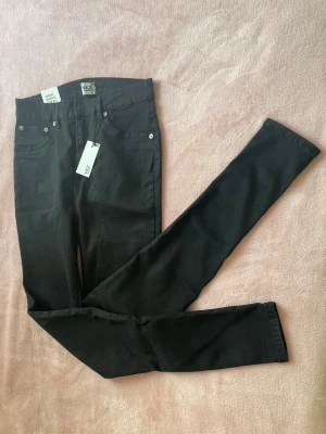 Svarta Snake jeans i storlek L - Snygga svarta jeans från Lager 157 i modellen Snake. Jeansen har klassisk femficksdesign, smala ben och och hög midja. Perfekta för dig som gillar en stilren och enkel look. Materialet är mjukt, stretchigt och bekvämt, passar till många olika outfits. 