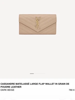 Beige quiltad plånbok från YSL - Säljer en stor beige plånbok från Saint Laurent i quiltat skinn med ikoniskt YSL-emblem i guld på framsidan. Plånboken har en klassisk kuvertform och elegant struktur. Perfekt för dig som vill ha både stil och funktion.