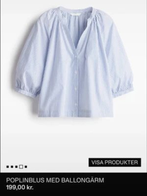 SÖKERRRR!! - Ljusblå poplinblus med tunna vita ränder och ballongärmar. Blusen har v-ringning, knäppning framtill och avslappnad passform. Perfekt för en trendig och luftig look.