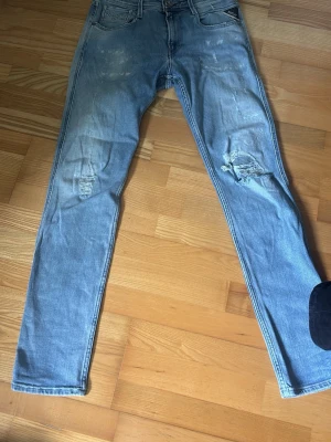 Replay jeans - Säljer ett par ljusblå skinny jeans med slitningar och hål på knäna. Jeansen har klassisk femficksdesign, dragkedjegylf och är i stretchigt denimtyg. Perfekta för en avslappnad streetstil. Nypris runt 1200kr mitt pris 450kr