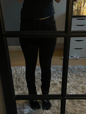 Svarta skinny jeans med hög midja - Säljer ett par svarta skinny jeans med hög midja och klassisk femficksdesign. Jeansen har smal passform hela vägen ner och är perfekta till en avslappnad eller trendig look. Materialet är stretchigt för extra komfort. Ej använt, ej bra pris,, skriv till mig. (Tror S extra tall herr)