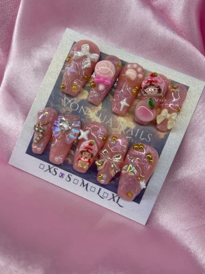  🍓Shortcake (S);Medium Ballerina  - Supergulliga handgjorda press-on naglar i rosa med glitter, (strawberry shortcake) 3D-dekorationer som rosetter, hjärtan, stjärnor, nalle, tass och figurer. Naglarna har en glansig finish och är dekorerade med små gulddetaljer och pärlor. Perfekt för dig som älskar kawaii och unika naglar.S: 15 mm, 11,5 mm, 12 mm, 11 mm, 9 mm 