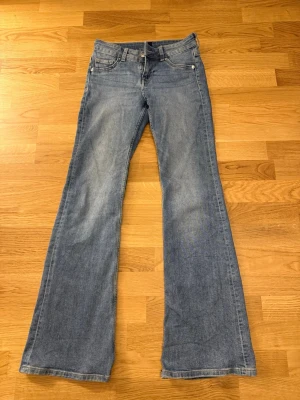Blå bootcut jeans med utsvängda ben - Säljer ett par blåa bootcut jeans med låg midja från HM, använda fåtal gånger 