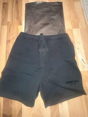 Essentials Fear of God sweatshorts i storlek M - Säljer ett par Essentials Fear of God sweatshorts i storlek M.  Helt nya och oanvända – prislapp sitter kvar och originalpåse medföljer.  Svart färg med broderad/tryckt Essentials-logo. Väldigt populär modell med avslappnad passform och hög kvalitet i materialet. Perfekta både till vardag och sommar.  • Storlek: M • Skick: 10/10 (helt nya) • 100% äkta  Kan skickas eller mötas upp. Hör av dig vid frågor.
