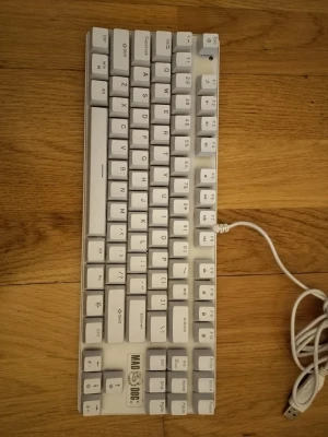Vit mekanisk tangentbord Mad Dog - Säljer ett vitt mekaniskt tangentbord från Mad Dog med USB-anslutning. Kompakt design utan numerisk del, tydliga vita tangenter och uppfällbara fötter på undersidan. Perfekt för gaming eller studier vid datorn.