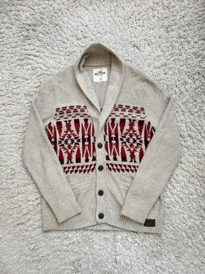 Beige Hollister kofta i storlek M - Schysst beige Hollister kofta med rött mönster och knappar Hör av er vid frågor!