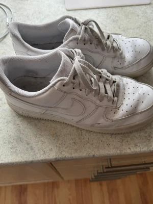 Nike Air Force 1 - Ett par vita Nike Air Force 1 sneakers. De är i använt skick med viss smuts och slitage men för den som har orken till att göra rent så kan de verkligen fräschas upp. Storlek 44