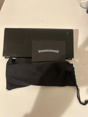 Chrome Hearts svarta glasögon - Snygga svarta glasögon från Chrome Hearts med fyrkantig form och detaljer i guld vid gångjärnen. Kommer med originalfodral, putsduk och äkthetskort. Perfekt accessoar för dig som vill sticka ut med stilrena och exklusiva detaljer.