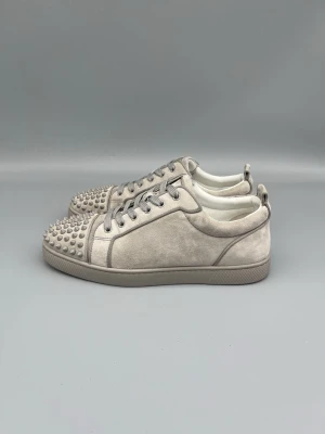 Louboutin skor i grå mocka med spikar  - • The shoes have been gently used and are in very good condition  • Size: 42 (fits 42.5–43)  • Color: Light Grey  • Retail price: 9500 SEK / 795€  • No accessories