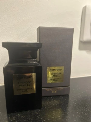 Tom Ford Tobacco Vanille EdP 100 ml - Lyxig parfym från Tom Ford i doften Tobacco Vanille. Flaskan är svart med en elegant guldetikett och har en unik, fyrkantig form. Innehåller 100 ml Eau de Parfum och levereras i originalförpackning. Perfekt för dig som gillar exklusiva och varma doftnoter. Helt ny