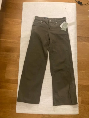 Lågmidjade gröna jeans  - Säljer ett par vida lågmidjade jeans som är helt nya med lappen kvar. Från hm i storek 34 