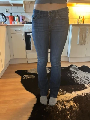 7 of all mankind jeans - Säljer ett par klassiska blå bootcut jeans från Nudie Jeans. Jeansen har normal midja, fem fickor och snygga kontrastsömmar. Materialet är mjukt denim med lite stretch för extra komfort. Perfekta för dig som gillar en tidlös och avslappnad look.