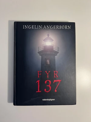 Fyr 137 av Ingelin Angerborn - En spännande ungdomsroman med svart hård pärm och motiv av en upplyst fyr på omslaget. Boken är skriven av Ingelin Angerborn och utgiven av rabén&sjögren. Perfekt för dig som gillar mysterier och nervkittlande berättelser.
