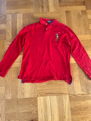 Sällsynt Polo Ralph Lauren vintage Big Pony polo tröja - Säljer den här väldigt sällsynta och snygga långärmade röda Big Pony polotröjan i storlek L från Polo Ralph Lauren (custom fit), med det ikoniska Big Pony märket broderat på bröstet samt sifferloggan på ena axeln. (3) Finns i princip inte att köpa längre förutom via second hand. Väldigt bra skick, inga defekter🔥