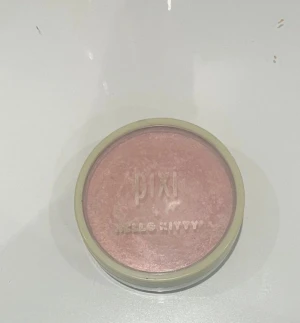 Pixi x Hello Kitty rosa rouge - Sött rosa rouge från Pixi i samarbete med Hello Kitty. Kommer i en rund dosa med ljusgrönt lock och präglad logga. Perfekt för att ge kinderna en fräsch och ungdomlig glow. Pudret har en silkeslen formula som är lätt att applicera.