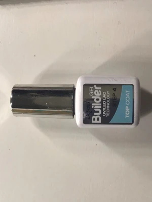 Builder Gel Top Coat UV/LED - Builder Gel Top Coat med UV/LED-teknologi, steg 4. Kommer i en vit och silverfärgad flaska med blå etikett. Perfekt för att ge naglarna en glansig och hållbar finish. Appliceras som sista steg vid gelnaglar.