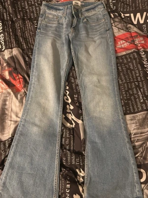 Ljusblå bootcut jeans från lager157 - Säljer ett par ljusblå bootcut jeans från lager157 med klassisk femficksdesign och utsvängda ben. Jeansen har en snygg tvättad look och är gjorda i mjuk denim. Perfekta för dig som gillar retrostil och vill ha ett par jeans som sticker ut.