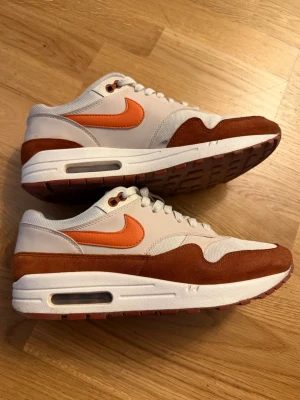 Nike Air Max 1 Mars Stone Rare - Nike Air Max 1 sneakers i beige mesh och läder med bruna mockadetaljer och orange swoosh. Klassisk Air Max-sula med synlig luftbubbla och gummisula i matchande färg. Perfekta för dig som gillar retrostil och streetwear. Är en rare modell. Ganska högt retail pris. Vill bli av med mina. Är givetvis äkta!