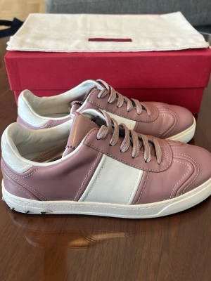 Rosa vita flycrews Valentino - Snygga sneakers i rosa och vitt läder från Valentino. Skorna har klassisk låg modell med vita detaljer och matchande snörnina. Sulan är vit med små nitar på sidan för en extra touch. Perfekta för dig som vill ha en stilren men ändå unik look. DAM strl 37. 9/10 skick ALLT INGÅR 