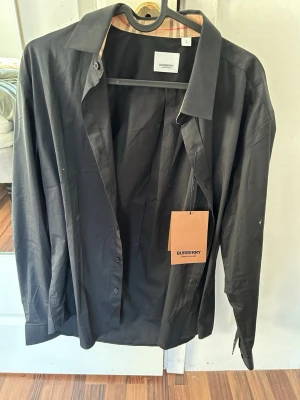 Burberry skjorta svart L - Liten i storlek sitter som M. Helt ny lapp kvar. Köpte den här på Plick. 