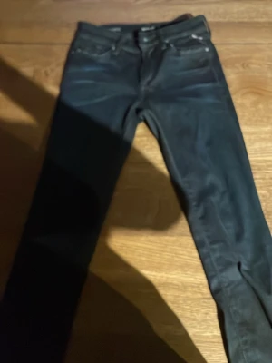Mörkblå skinny jeans från Replay - Säljer ett par mörkblå skinny jeans från Replay med klassisk femficksmodell och silverfärgade nitar. Jeansen har en smal passform och är tillverkade i stretchigt denimtyg för extra komfort. Perfekta till en avslappnad streetstyle-look.