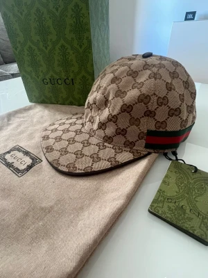 Gucci keps - HELT NY KEPS ALDRIG ANVÄND! Passar med allting, väldigt snygg och clean för sommaren. Säljer den billigt för att den inte passar mig. Pris kan diskuteras! 