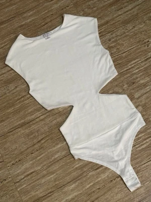 Vit ärmlös bodysuit med cut-out - Säljer denna slutsålda virala body från Newyorker! Aldrig använd, storlek S💕