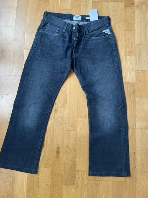 Mörkblå jeans från replay - Snygga mörkblå jeans från replay Jeans med klassisk femficksmodell och raka ben. Jeansen har knappgylf och diskreta slitningar för en cool look. Tillverkade i slitstark denim som passar perfekt till din vardagsstil.