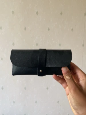 Svarta solglasögon med gulddetaljer - Säljer ett par riktigt snygga solglasögon med svart båge och guldfärgade detaljer på sidorna. Glasen är rektangulära och har en snygg toning. Kommer med ett svart fodral i skinnimitation. Perfekta för dig som vill sticka ut i sommar!