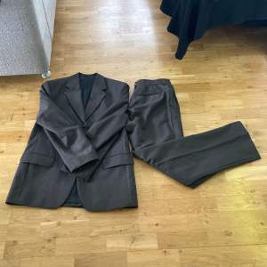 En riktigt snygg mörkbrun vintage kostym i bra skick. Ingen sizetag men skulle säga att den passar som M ungefär.
