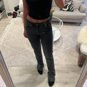 Grå jeans - Gråa lågmidjade jeans med slits vid foten.