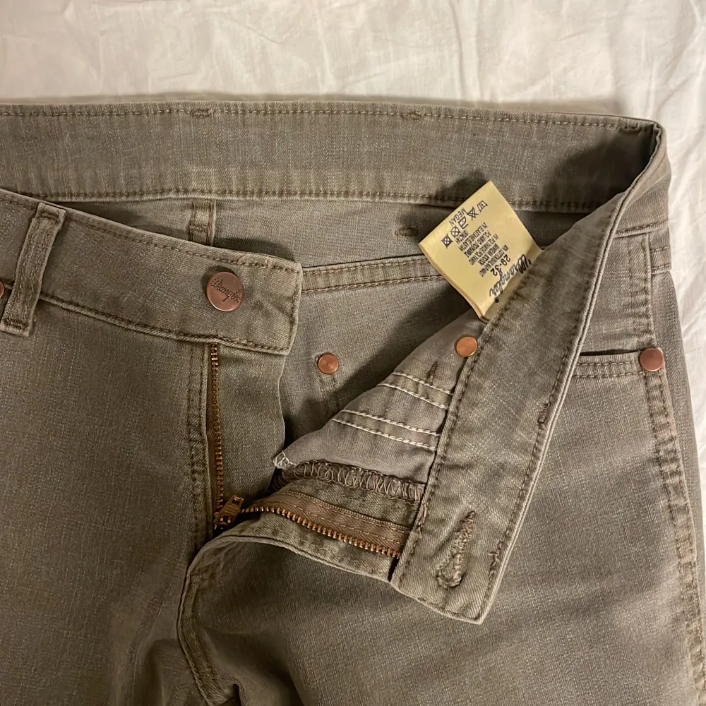 Utsvängda jeans från wrangler i storlek 29/32. De är gråa med lite nyans av militärgrönt. Jag är 167cm och de passar bra i längden. . Jeans & Byxor.