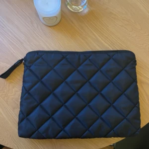 Datorfodral - Svart datorfodral från H&M. Kommer med tillhörande axelrem om man vill addera det. Mått är ca 40x30cm.