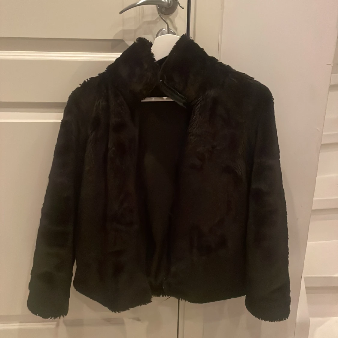 En svart pälsjacka storklek: 152 (11-12år). 100kr