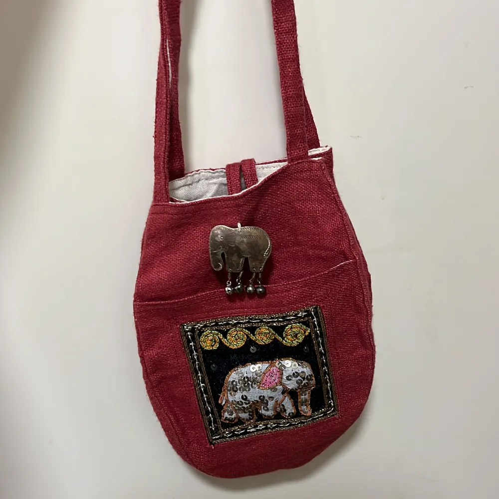 Liten, vinröd, handväska med elefant print. Väskor.