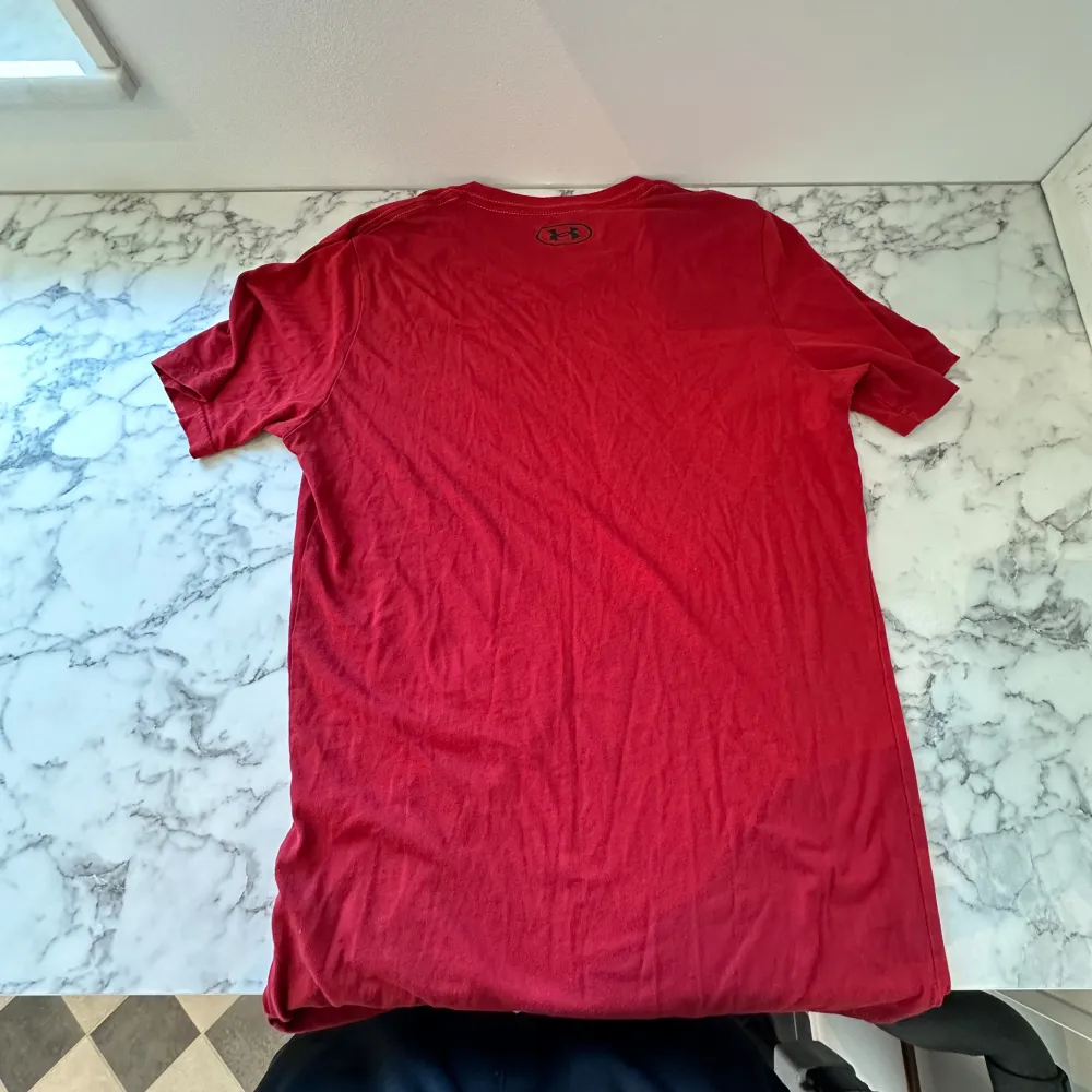 En röd under armour tröja i storlek XS. Tröjan har använts endast ett par gånger och ser ut precis som ny. Tröjan är luftig och relativt tunn och funkar därför perfekt att använda i sommarvädret. Tröjan känns även aningen större än XS. . T-shirts.