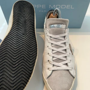 Philippe Model - Riktigt snygga skor från Franska Lyxmärket Philippe Model! Väldigt bra skick 9+/10. Storlek 41 och passar 41-42. Box och kort ingår. Slitningarna ingår i designen och är inte defekter. Hör av er vid frågor!!!