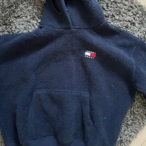 Säljer denna tommy hilfiger hoodie i teddy material. Den är i förgen marinblå och knappt använd så i väldigt fint skick. 