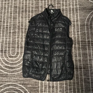 Armani väst - Tjenare! jag säljer den här feta västen då jag inte använder den längre. Skick 7/10. Den har inga defekter förutom att den har ett hål i sin fick vilket ni kan se i fjärde bilden. Nypris:1500kr. Skriv om ni har frågor!