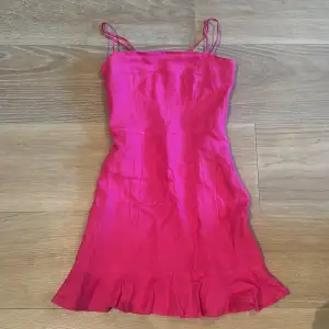 Världens finaste rosa klänning med volang längst ned i 100% linne som tyvärr blivit för liten! Reglerbara axelband.