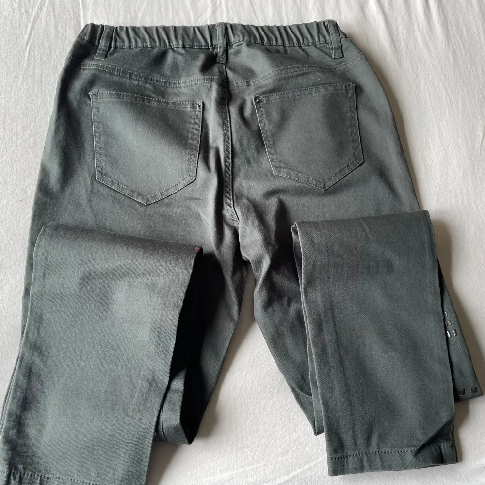 Grå byxor / leggings med nitar på framsidan och resår i midjan   Finns i Fredhäll. Jeans & Byxor.