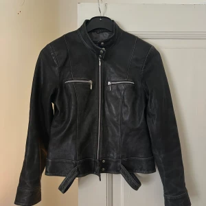 Svart läderjacka - Svart Rock n Blue läderjacka i storlek M. Gammal läderjacka som legat i garderoben i 2 år.  Den är i bra skick och enligt mig ännu snyggare nu då den använts lite.