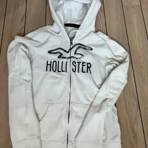 Hollister hoodie i fint skick säljes.  Färg: vit med mörkblå detaljer  Storlek: Small