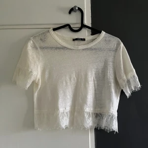 Vit spets topp  - Så fin vit spets topp ifrån Zara, använd fåtal gånger och i bra skick, toppen är så lätt att styla med andra plagg, toppen passar XS-S
