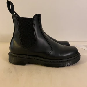 Dr Martens chelsea boots - Superfina Chelsea boots från Dr Martens. Modellen heter 2976 Mono, alltså helsvart med svart sula och svarta stygn.   Storlek: 41  De är sparsamt använda och har väldigt mycket kvar att ge. 