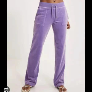 Lila juicy couture byxor - Lila juicy byxor i storlek S. Knappt använda. Sitter som en XS/S. Ljus lila färg. Väldigt bekväma och köpts från juicy couture hemsidan! (Köptes år 2023)❤️dem är knappt använda så jag skulle säga att det är nyskick på dem